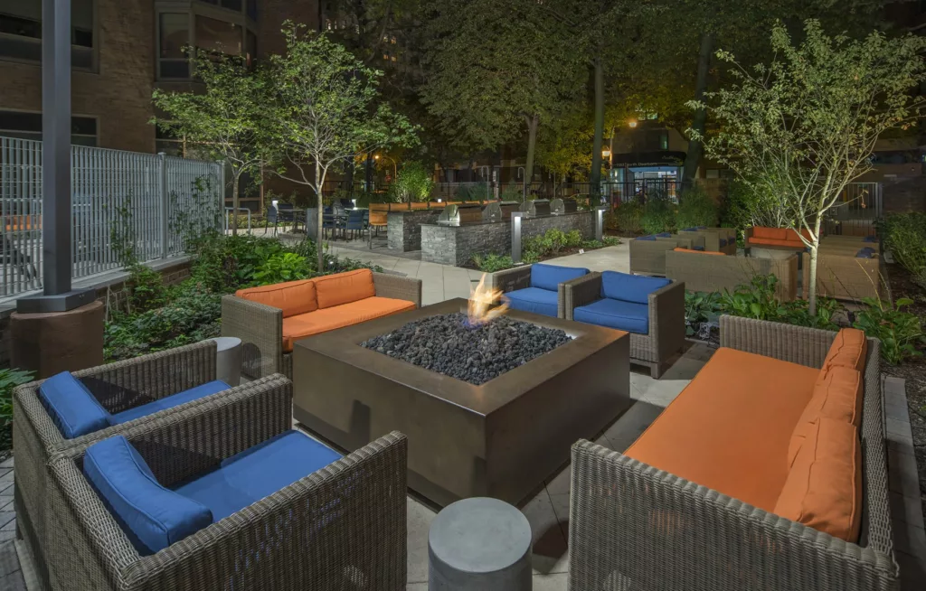 A cozy outdoor fire pit and lounge chairs at Elm Street Apartments in Chicago's Gold Coast