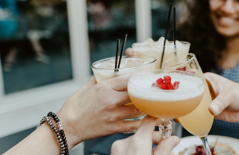 A close-up shot of a group of friends toasting their drinks together.
